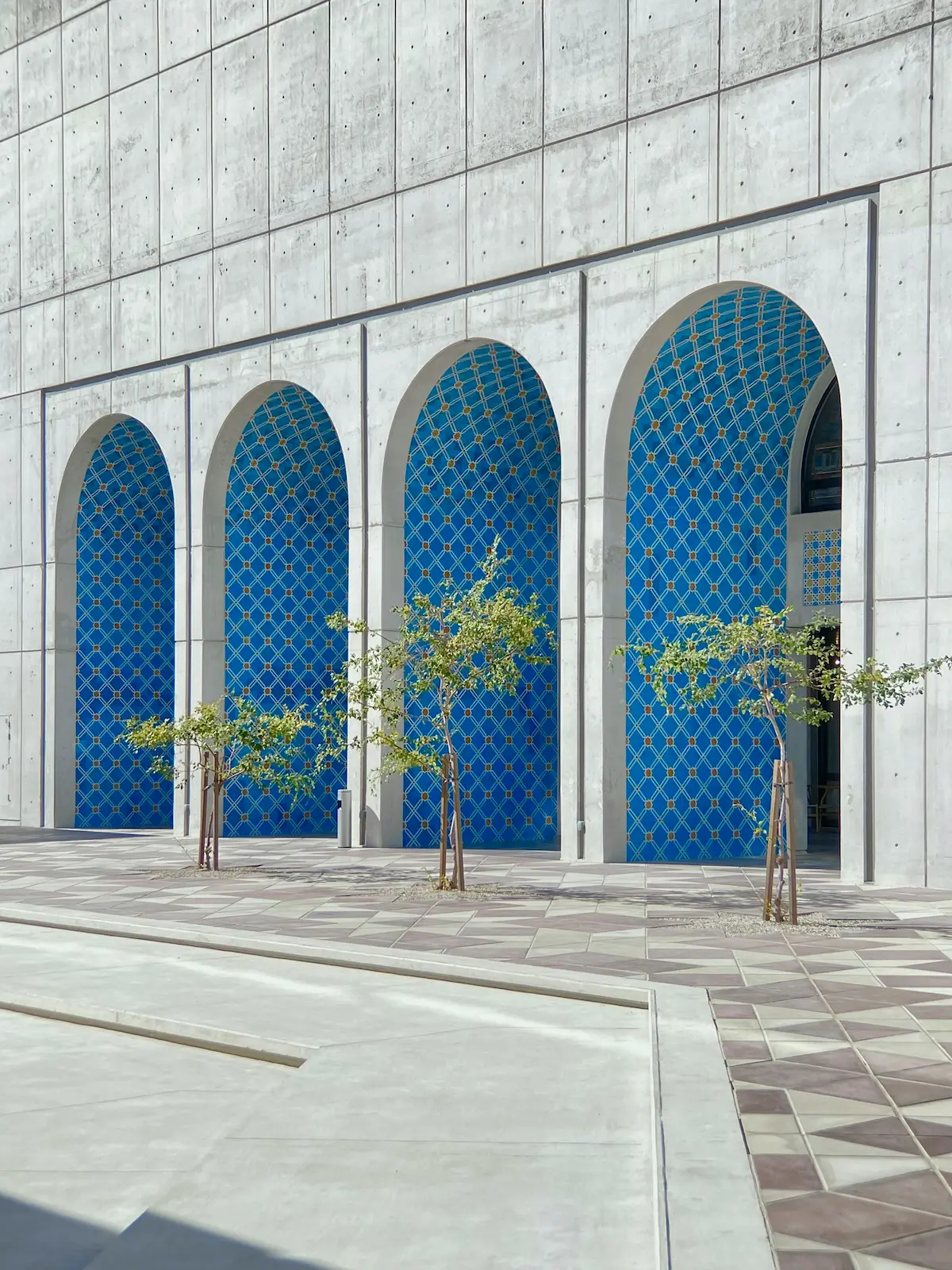 عمارة شرق أوسطية عصرية في أبوظبي بواجهات مقوّسة ونباتات خضراء، مصمّمة لحياة مريحة